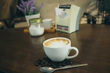 Coffee cup and coffee beans on wooden table  in cafe