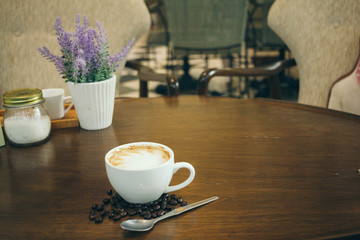 Coffee cup and coffee beans on wooden table  in cafe
