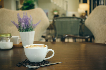 Coffee cup and coffee beans on wooden table  in cafe