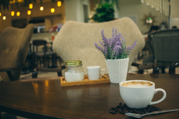 Coffee cup and coffee beans on wooden table  in cafe