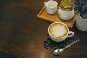 Coffee cup and coffee beans on wooden table  in cafe