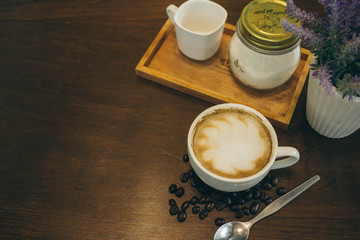 Coffee cup and coffee beans on wooden table  in cafe