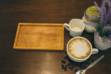 Coffee cup and coffee beans on wooden table  in cafe