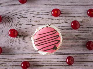 Fototapeta na wymiar One cupcake with ripe cherries on the table. Flat lay.