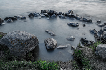 sunset at Willow Beach Georgina Ontario Canada with rocks formation, sky, clouds, light, and lake view