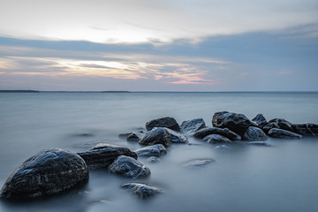 sunset at Willow Beach Georgina Ontario Canada with rocks formation, sky, clouds, light, and lake view