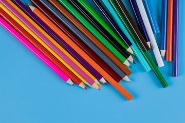 Colored pencils on blue background for art and school