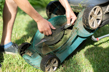 gardener repair and fix the a lawn mower in garden