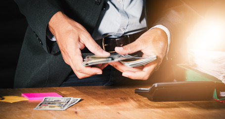 Businessmen count money and plan finances for projects and use calculators for analysis project documents and graph financial diagram working in the background on office table