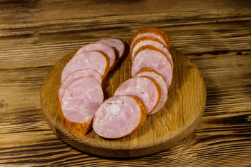 Sliced smoked sausage on cutting board on wooden table