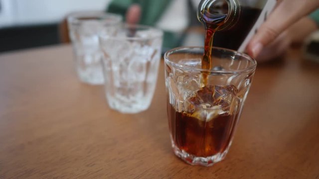 coffee cup, Pour coffee into a glass with ice, cold brew coffee, slow-motion in 4k