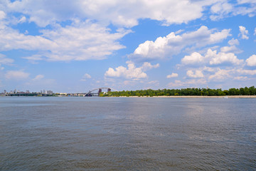 View of the river and away the forest with the beach. Sky with white clouds.