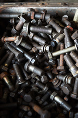 Blurred close up of old steel nuts and bolts in tool box