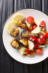 Gourmet food fried eel with fresh vegetable salad close-up on a plate. Vertical top view