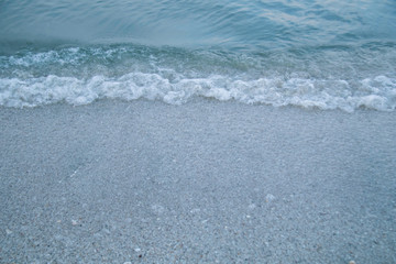 Beautiful sea beach with sun light reflection and bubble foam of sea wave with copy space