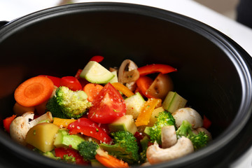 Adding salt to vegetables in multi cooker, closeup