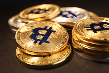 Shiny gold bitcoins on dark background, closeup view. Digital currency