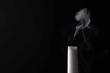 Smoldering candle wick and smoke on dark background, space for text