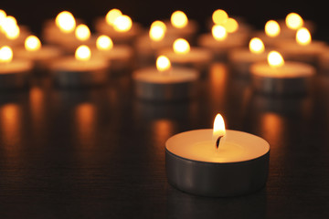 Burning candles on wooden table, space for text. Symbol of sorrow - obrazy, fototapety, plakaty
