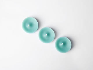 Light blue wax decorative candles isolated on white, top view