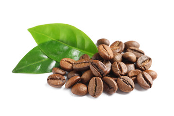Roasted coffee beans and fresh green leaves on white background
