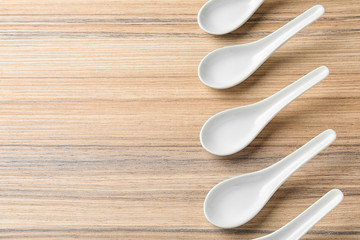 Miso soup spoons on wooden table, flat lay. Space for text