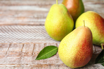 Ripe juicy pears on brown wooden table, closeup. Space for text