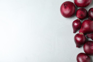 Ripe red onions on grey table, top view with space for text