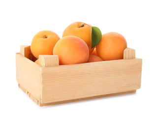 Wooden crate of delicious ripe sweet apricots isolated on white