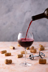 Red wine is poured into a glass. The concept of winemaking. Place under your text.