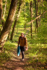One young man, in forest alone, trekking, walking. Carrying camp
