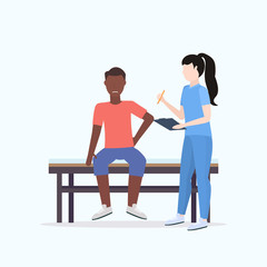 doctor holding clipboard female therapist consulting injured african american male patient sitting on bed manual sport physical therapy concept full length