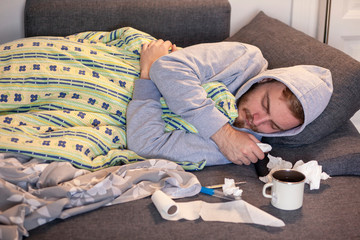 One young man, sleeping in bed, feeling sick.