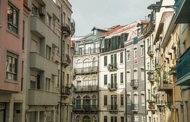Perspective of bend street in old town. Architecture in different styles. Windows and balconies with flowers