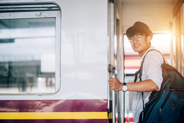 Asian man is traveler, he is waiting for their train. Outdoor adventure travel by train concept....