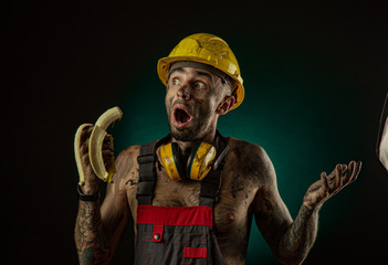 Portrait of a happy smiling miner eating a banana for lunch