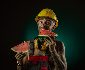 Portrait of a happy smiling miner eating watermelon for lunch