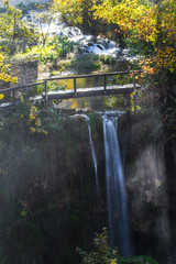 Fototapeta premium The wooden small bridge and a waterfall