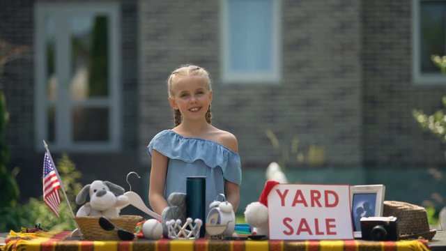 Girl selling old toys on yard sale, earning pocket money, young business lady