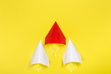 Group of white paper plane in one direction and one yellow paper plane pointing in different way on blue background. Business for innovative