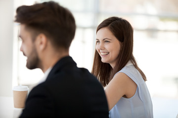 Happy young businesswoman have conversation with colleague at briefing