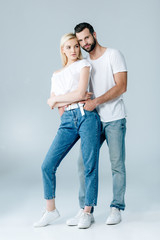 man and beautiful young woman in denim hugging on grey