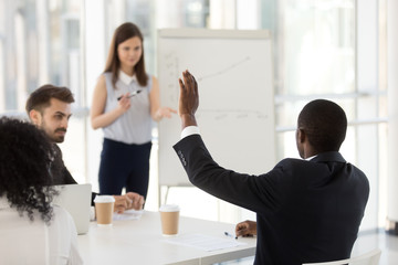 African American businessman ask question at company meeting