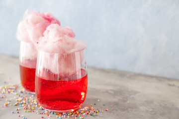 Glasses with tasty cotton candy cocktail on grunge table