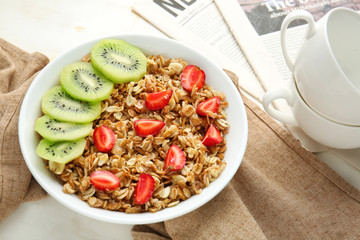 Bowl with tasty sweet oatmeal on table