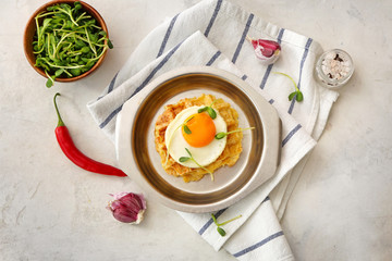 Plate with tasty squash waffles and fried egg on light background