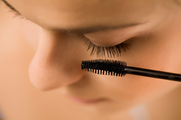closeup of woman applyinh mascara on her eyelashes
