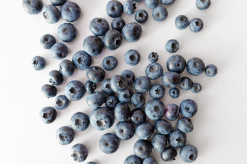 Blueberries scattered on a white table.