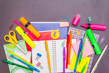 Back to school concept. School education supplies on black stone concrete background.