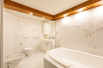 Bathroom with white tiles and wooden ceiling